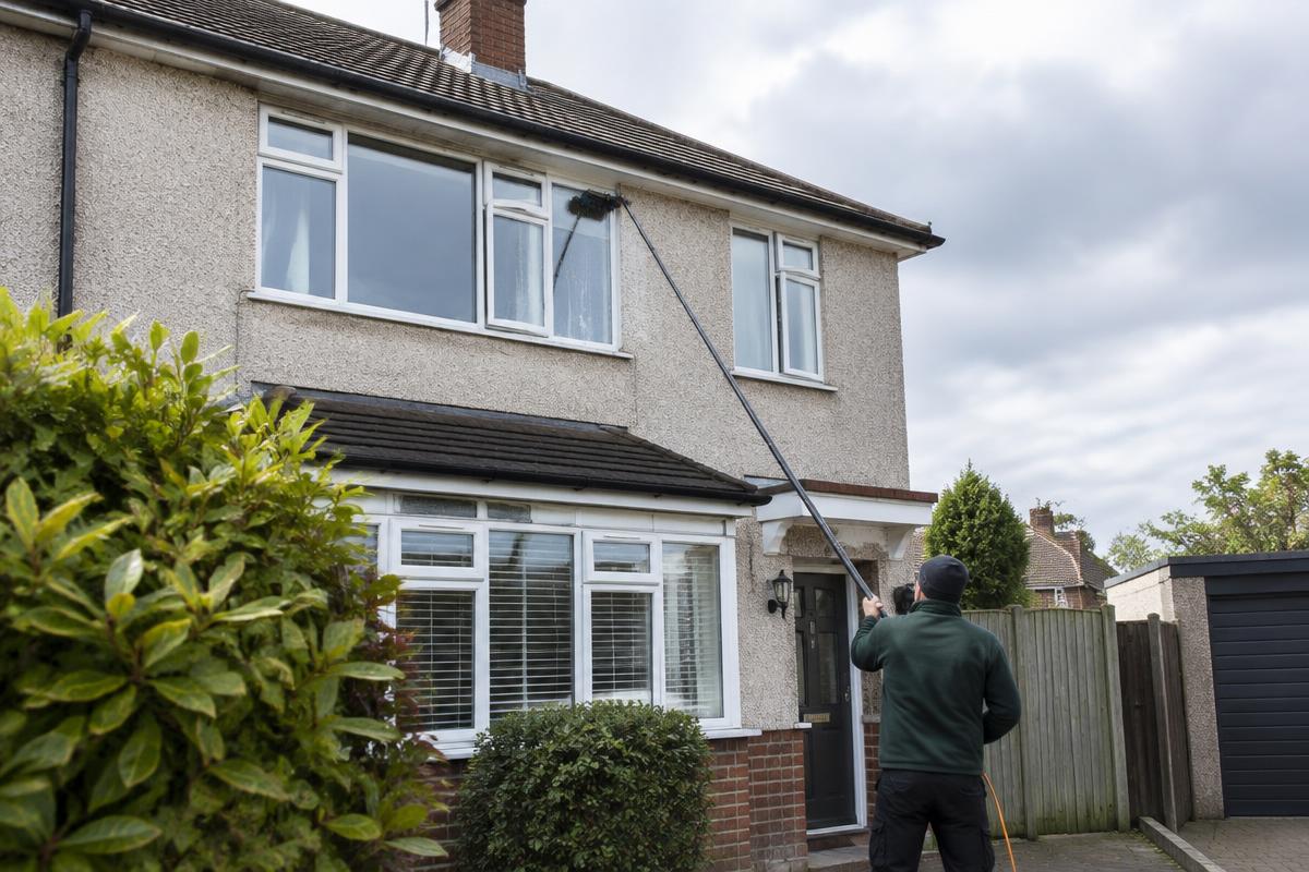 Residential windows being cleaned with a water-fed pole
